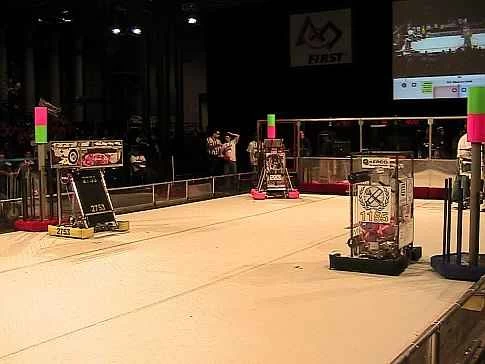 ニューヨーク市で開催された 2009 FIRST ロボティクス コンテストで、観衆の前で競技場に並んだ数台のロボット。