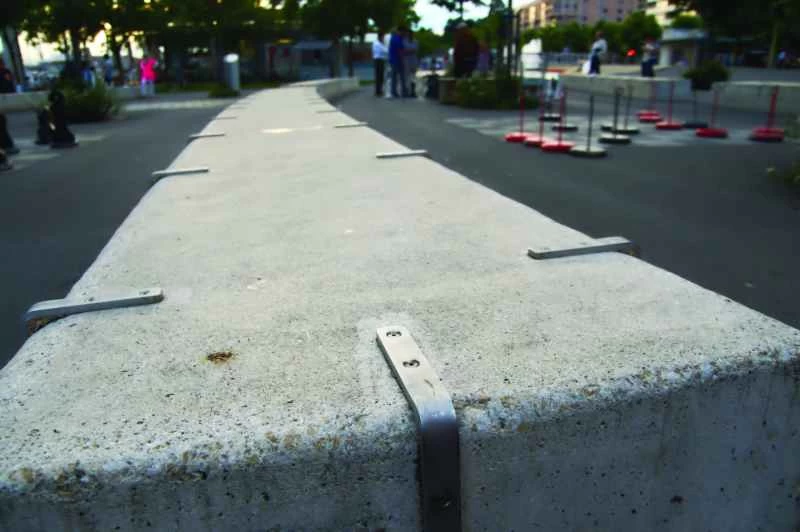 縁に沿って金属製の滑り止めバーが取り付けられた低い壁。