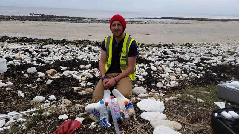 ゴミにまみれたビーチにいる男性